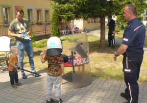 Chłopiec mierzy policyjny kask